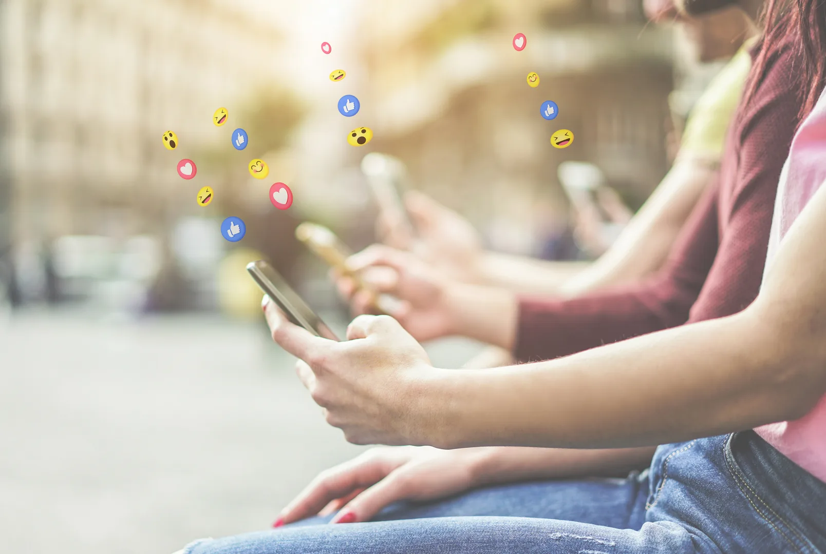 Young people using smartphones with social media emoji reactions